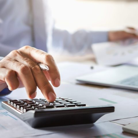 accountant working on desk using calculator for calculate financ Man werkt aan zijn bureau met rekenmachine